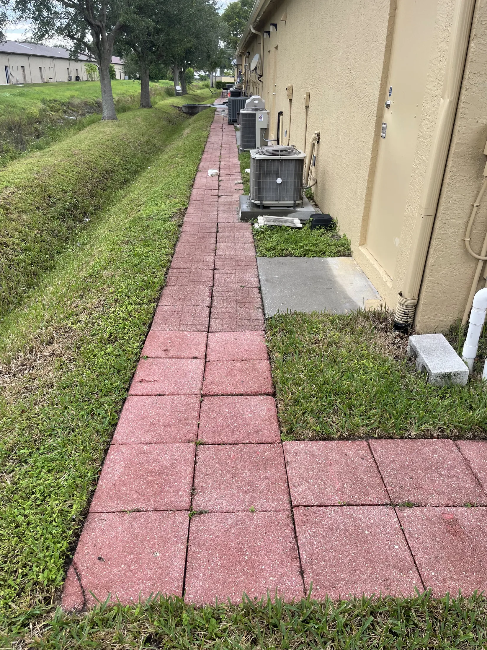 Red paver path beside a home