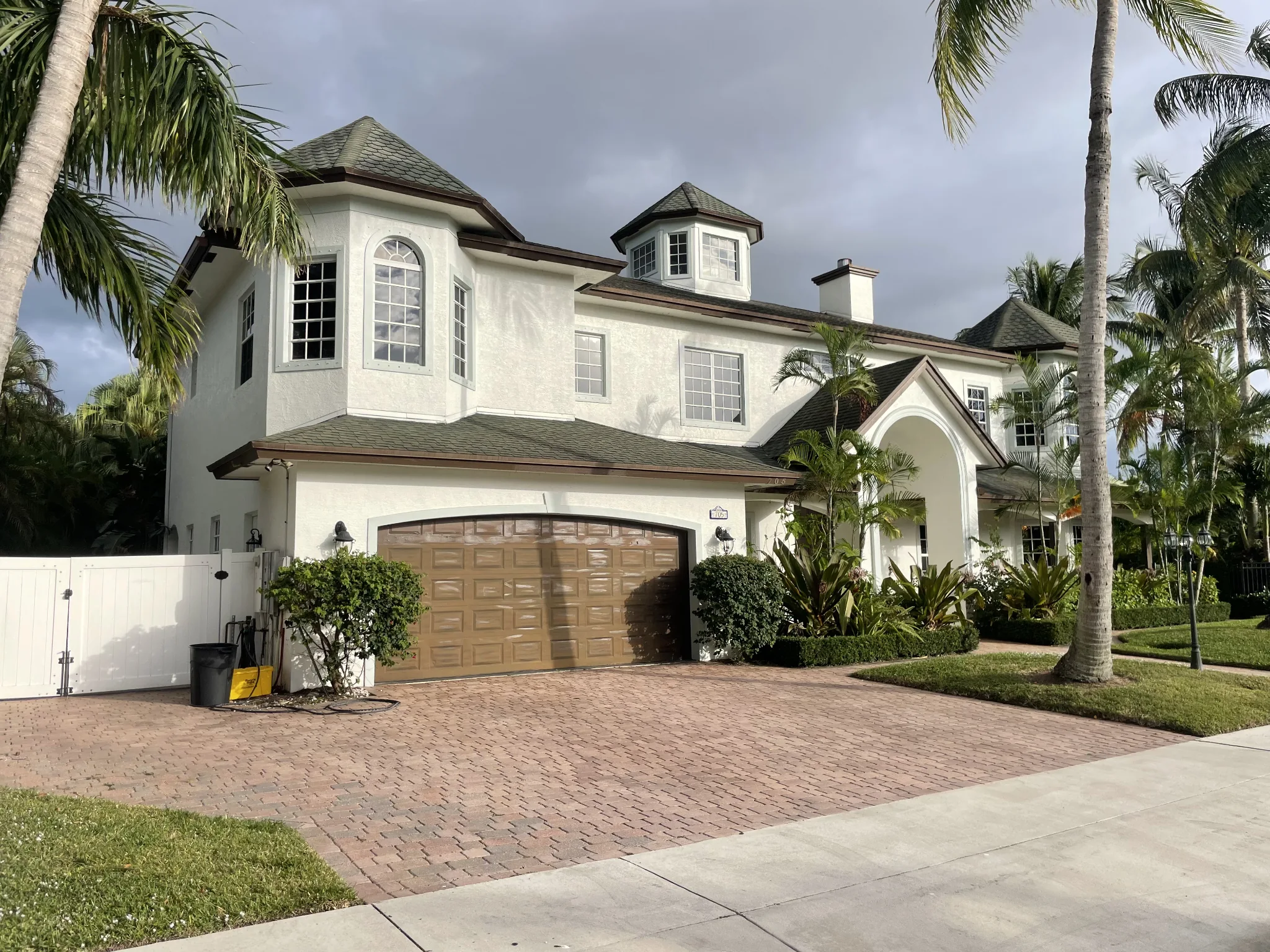 White South Florida home with roof, windows, walls, gutters and brick paver driveway